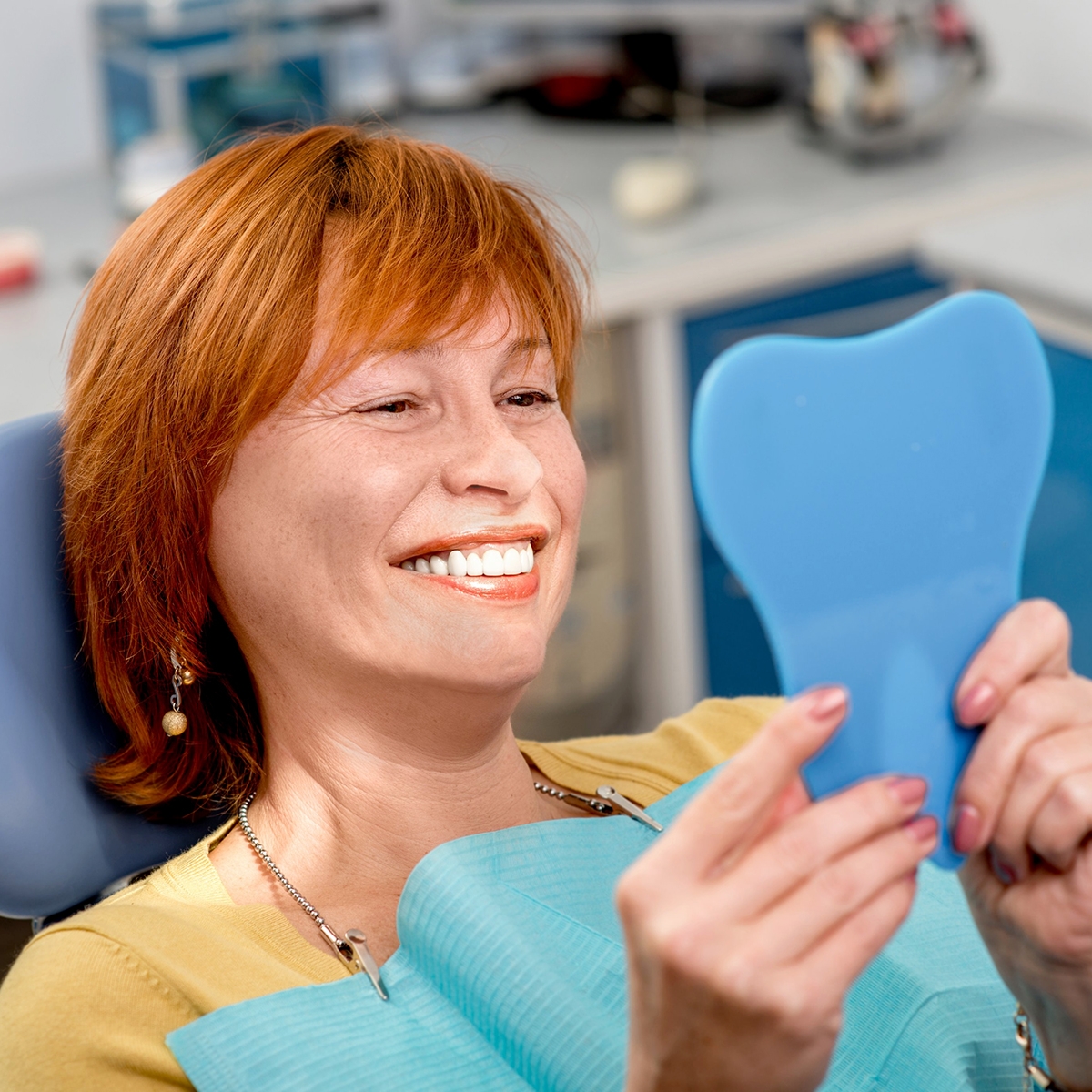 woman looking at her teeth in mirror